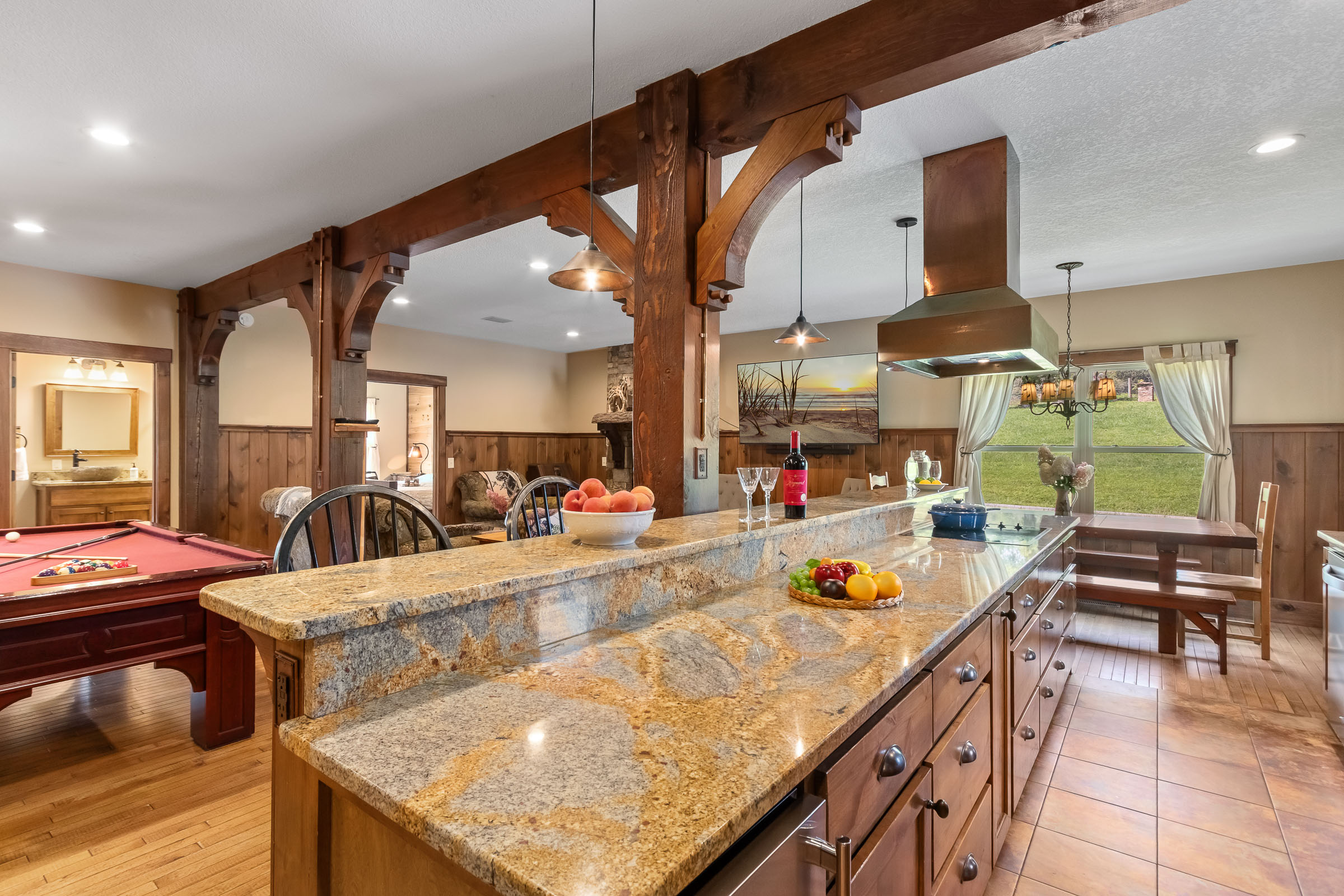 Kitchen island and pool table gathering area inside The Millhouse Lodge
