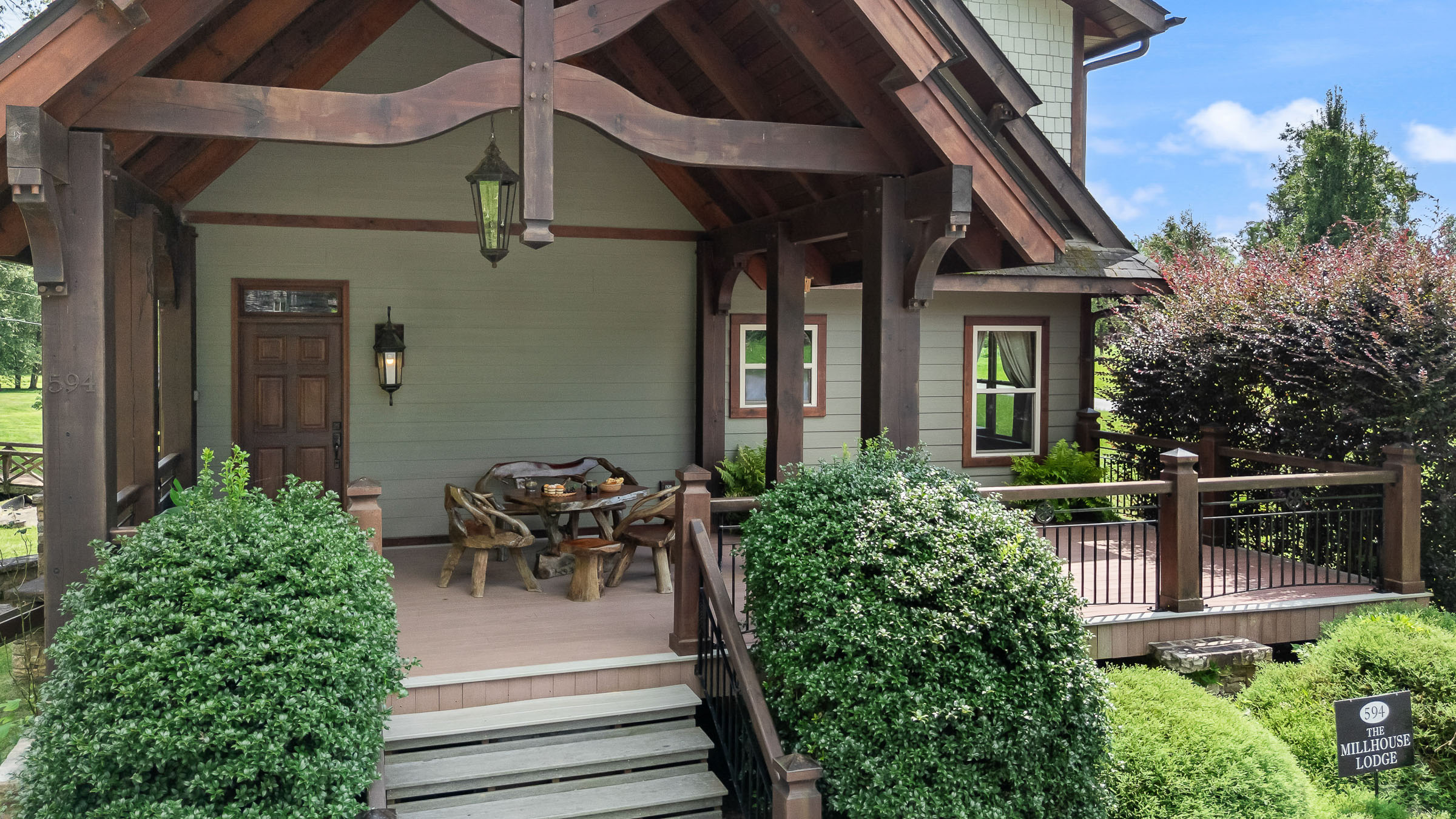 Covered porch at The Millhouse Lodge with timber beams and rustic seating for wedding weekend portraits